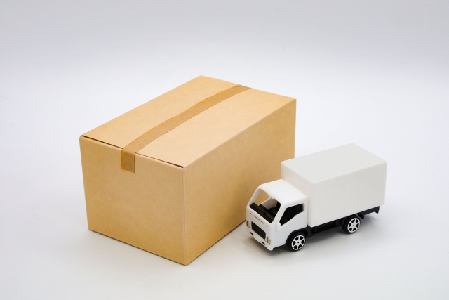 ダンボール箱と小さな白いトラックの模型